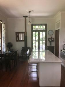 a kitchen and dining room with a table and a window at Mount Browne Cottage in Coffs Harbour