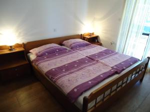 サヴドリアにあるStudio Apartment Carliのベッド1台(紫色の掛け布団、枕2つ付)