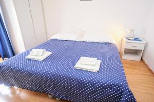 1 dormitorio con 1 cama azul y 2 toallas en Apartment Daniela, en Savudrija