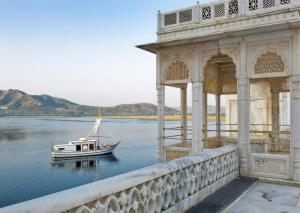 a boat on the water next to a building at Taj Lake Palace Udaipur in Udaipur