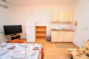 a living room with a refrigerator and a tv at Apartment Daniela in Savudrija