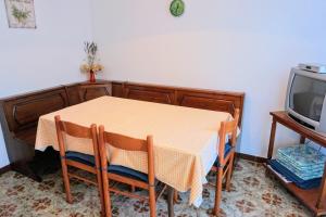 einen Esstisch mit 2 Stühlen und einen TV in der Unterkunft Apartment Vilma in Savudrija