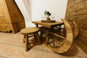 a wooden table with two wine glasses and a chair at Hotel Superski in Cavnic