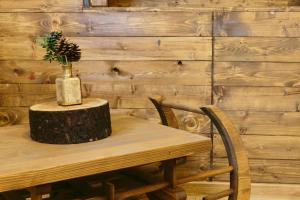 a wooden table with a vase on top of a tree stump at Hotel Superski in Cavnic