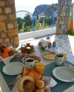 a breakfast table with toast and coffee and orange juice at Bella Vista Stegna in Archangelos