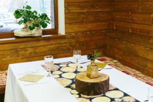 a table with wine glasses and a tree stump on it at Hotel Superski in Cavnic