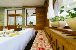 a dining room with a long table and a piano at Hotel Superski in Cavnic