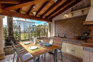 a kitchen with a wooden table and chairs in a kitchen at Apartment Rosmare in Alcudia