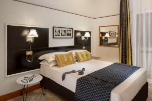 ローマにあるAmalia Suites by Remember Romeの大きなベッドと鏡が備わるホテルルームです。