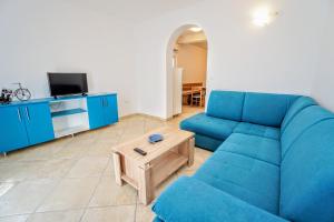 a living room with a blue couch and a table at Apartment Nino Savudrija in Bašanija