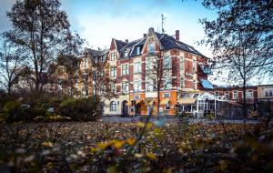 a large building with a lot of leaves in front of it at Hotel Heinz in Plauen
