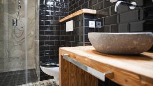 a bathroom with a sink and a toilet at ALPENLIEBE Design Hotel in Inzell