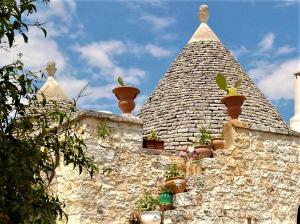 a building with potted plants on top of it at Trulli Fogliarella in Ostuni