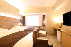 מיטה או מיטות בחדר ב-Kobe Luminous Hotel Sannomiya