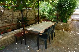 einen Holztisch und Stühle im Garten in der Unterkunft Apartment Vilma 2 in Bašanija