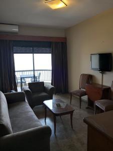 a living room with a couch and chairs and a tv at Holiday Suites Hotel & Beach Resort in Jounieh