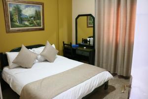 Schlafzimmer mit einem Bett, einem Schreibtisch und einem Spiegel in der Unterkunft Holiday Suites Hotel & Beach Resort in Jounieh