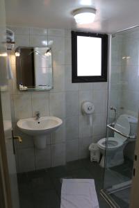 a bathroom with a sink and a toilet and a window at Holiday Suites Hotel & Beach Resort in Jounieh
