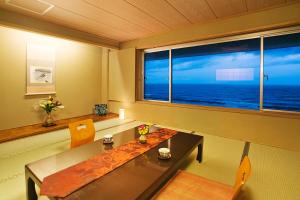 a dining room with a table and a large window at Senami View Hotel in Senami
