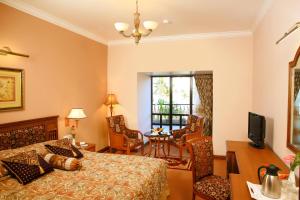 Habitación de hotel con cama, mesa y sillas en Regant Lake Palace Hotel, en Nīndakara
