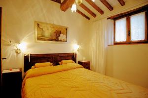 a bedroom with a bed with yellow sheets and two windows at Casa Margherita 3 by PosarelliVillas in Piegaio