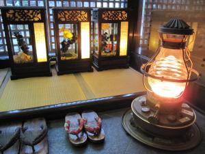 Zimmer mit einer Lampe und zwei Schuhpaaren in der Unterkunft Dyeing and Hostel Nakashimaya - Female Only in Kumamoto