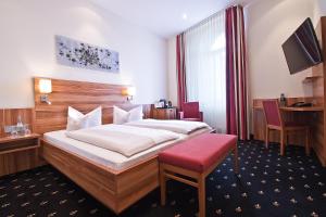 een hotelkamer met een bed en een rode bank bij Hotel Panorama in Heidelberg