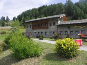 un antiguo edificio de piedra en medio de un campo en Hotel Les Granges en La Thuile