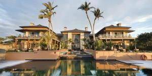 a house with a swimming pool and palm trees at Pezula Nature Retreat in Knysna +168 photos
