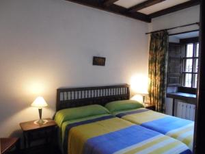 a bedroom with two beds with green and blue sheets at Casa Rural La Central-Peñagorda in El Barco de Ávila