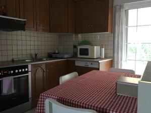 a kitchen with a table with a red and white checkered table cloth at COZY & QUIET CITY APARTMENT in Tríkala