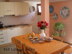 a dining room table with a vase of flowers on it at B&B L'alba Nel Golfo in Castelsardo +73 photos