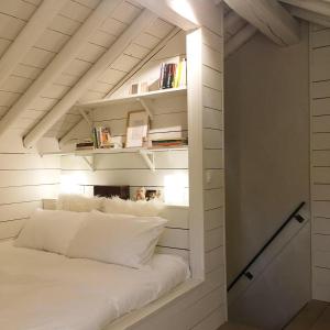 a room with a white bed in a attic at Le Nid in Manhay