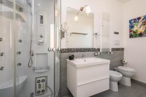 a white bathroom with a sink and a toilet at Villa Francesco...graziosa, moderna, confortevole! in Lascari +20 photos