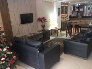 a living room with two couches and a christmas tree at Hotel Steinhausen in Blumenau