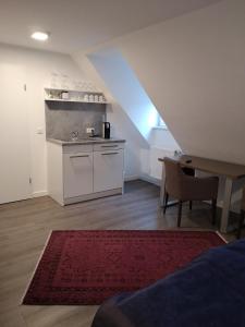 eine Küche mit einem Waschbecken und einem Tisch in einem Zimmer in der Unterkunft Trip Inn PostApart Aschaffenburg in Aschaffenburg