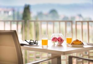 stół z dwoma kieliszkami i talerzem jedzenia i soku pomarańczowego w obiekcie Remisens CASA ROSA - Hotel Metropol Annexe w Portorožu