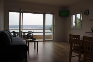 a living room with a couch and a table and chairs at Villa Marina in Omiš