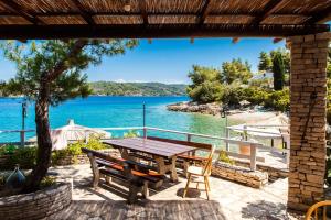 a picnic table with a view of the water at Pebble Bay Paradise House in Vela Luka