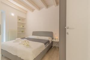 Dormitorio blanco con cama y mesa en Little Nest Flat, en Varenna