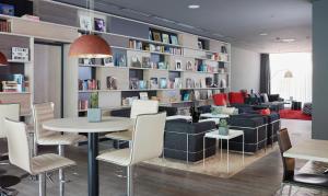 - un salon avec un canapé, une table et des chaises dans l'établissement Living Hotel Frankfurt, à Francfort-sur-le-Main