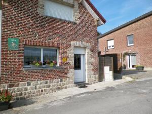 a brick building with flowers in a window at Gîte les Prairies in Maresches