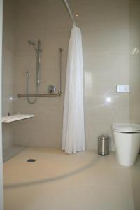 a white bathroom with a shower and a toilet at Pine Hill Lodge In Vineyard in Mapua +34 photos