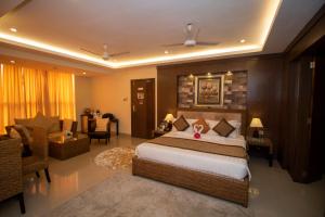 Un dormitorio con una cama y una sala de estar. en Hotel KRC Palace, en Tezpur