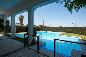 une maison avec une piscine et une clôture dans l'établissement Relaxing Villa w/pool up to 6 people Cascais, à Cascais