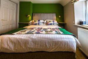 a bedroom with a large bed with green walls at Washingborough Hall Hotel in Lincoln