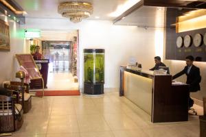two people sitting at a counter in a restaurant at Hotel KRC Palace in Tezpur