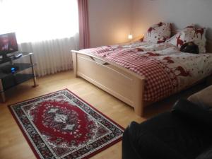 a bedroom with a bed with a red blanket and a rug at Appartement Draublick in Unterpudlach