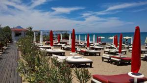 a bunch of chairs and umbrellas on a beach at Il Muretto in Lascari