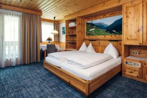 a bedroom with a large bed in a wooden room at Wellnesshotel Engadin in Samnaun